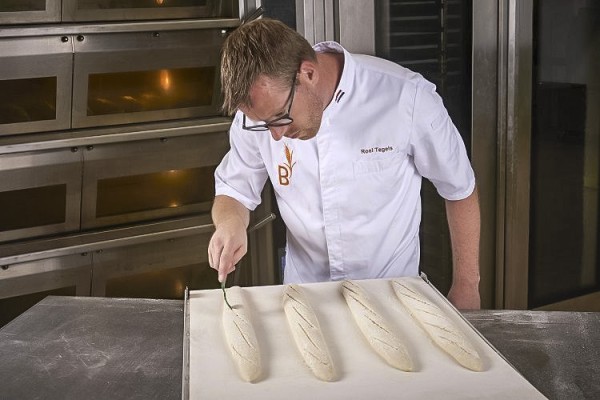 Baguette 6 Bakker maakt inkepingen in het deeg van een baguette.jpg