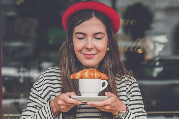 Croissant 14 vrouw geniet van koffie met croissant tijdens vakantie in Frankrijk.jpg